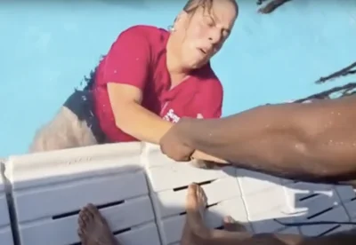 Screenshot from a video showing Sunset Pool manager Christine Giunta-Mayer being fished out after being pushed into the pool.  